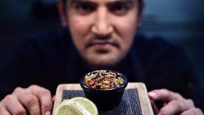 El Topo sous-chef Nowshad Alam Rasel shows off his restaurant's signature cricket dish in Sydney on March 16, 2017. Saeed Khan / AFP