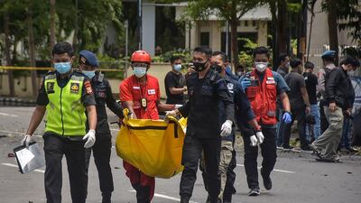 Police carry a bag with the remains of a suspected suicide bomber after an explosion outside a church in Makassar. AFP