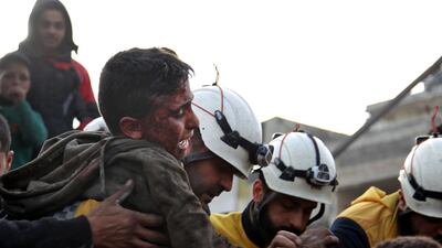 Members of the Syrian Civil Defence, also known as the White Helmets, recover a wounded boy from the rubble of a building. AFP