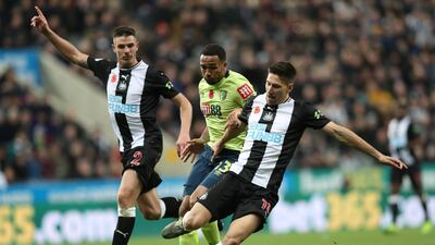 Newcastle United's Ciaran Clark and Federico Fernandez take on Bournemouth's Callum Wilson. Reuters