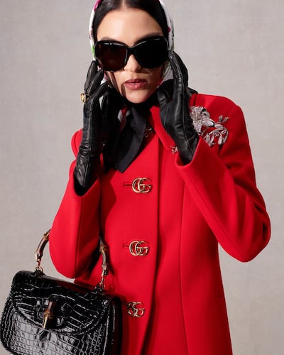 The Incazzata coat in red natte wool and the Bamboo 1947 by Gucci. Photo Gucci