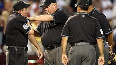Home plate umpire Marty Foster, left, is tended to by crew chief Wally Bell after being struck by a foul ball during the major league baseball game between the San Francisco Giants and the Arizona Diamondbacks at Chase Field.