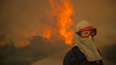 A female firefighter battles a blaze during a fire spreading rapidly through residential areas in the mountainous suburb of Simonstown in Cape Town, South Africa. Hundreds of residents are being evacuated as the fire fanned by strong north westerly winds started in Ocean View ripped through Glencairn heading towards Simonstown according to eye witness reports at the scene. Nic Bothma / EPA