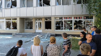 Locals inspect the damage to a building near the impact area of a rocket strike in Lviv. EPA