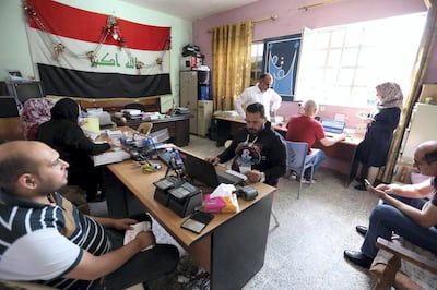 Iraqis visit an electoral commission office to renew their voting registry records and issue new IDs to be able to vote in the upcoming May parliamentary elections, in the Adhamiya neighborhood in Baghdad. Alia Abbas / EPA