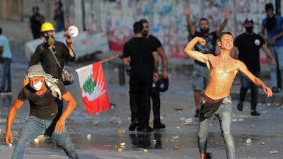 Lebanese protesters throw stones during clashes with the army and security forces in Downtown Beirut on the anniversary of the port blast that devastated the city last year. Hundreds of Lebanese marched today to mark the cataclysmic explosion, protesting against impunity over the country's worst peacetime disaster at a time when its economy was already in tatters.