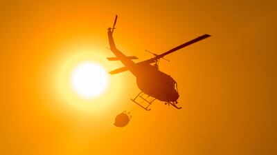 A helicopter carries water to a drop point over the Detwiler fire in Mariposa, California. Josh Edelson / AFP
