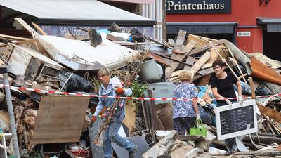 People carry items while attempting to clear an area affected by floods caused by heavy rainfall in Bad Muenstereifel, Germany.