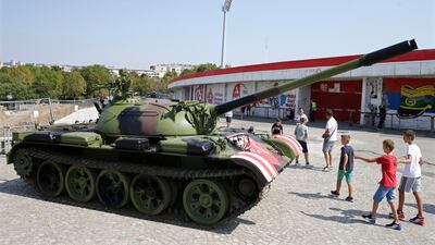 Boys walk past a former Yugoslav army T-55 battle tank in front of the northern stand of the Rajko Mitic stadium in Belgrade. EPA