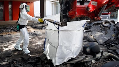 Worker directs a mechanical shovel grabbing pieces of destroyed surfacing to gather up the lead particles in the school yard of Saint Benoit primary school in Paris, France. AP photo