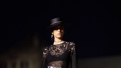 A model wears a full skirt with a sheer lace top during the Spanish-inspired Dior Cruise 2023 show. Getty Images
