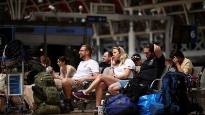 Travellers wait for a train at Paddington station in London. Reuters