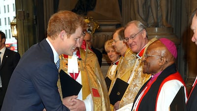 Britain's Prince Harry, now known as the Duke of Sussex, shakes hands with Tutu as he arrives at Westminster Abbey in London for a memorial service for the former South African president Nelson Mandela. PA