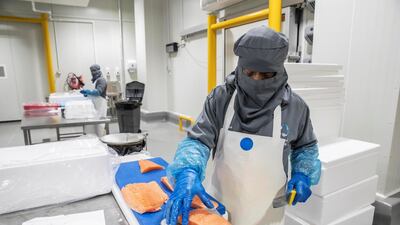 A worker preparing salmon imported from Europe