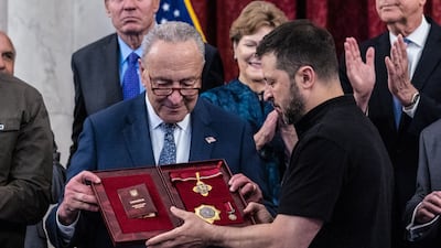 Mr Zelenskyy presents Senate Majority Leader Chuck Schumer with Ukrainian medals at the US Capitol. Getty Images / AFP