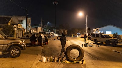 Community members gather around a road block they set up in Phoenix Township, North Durban, on July 15, 2021.