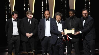 Christophe Barral, Toufik Ayadi, Kleber Mendonca Filho, Ladj Ly and Juliano Dornelles, winners of the Jury Prize award for their films "Les Miserables" and "Bacurau" pose with Michael Moore on stage at the Closing Ceremony during the 72nd annual Cannes Film Festival on May 25, 2019 in Cannes, France. Getty Images
