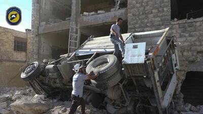 Rescue workers from the Syrian Civil Defense group known as the White Helmets remove a destroyed ambulance outside the Syrian Civil Defense main centre after airstrikes in Ansari neighborhood in the rebel-held part of eastern Aleppo, Syria, on Friday, September 23, 2016. Photo: Syrian Civil Defense White Helmets via AP