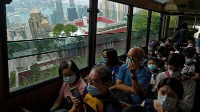 Passengers enjoy a view from the cabin as a Peak Tram goes downhill of the Victoria Peak in Hong Kong on June 17, 2021. Vincent Yu / AP Photo