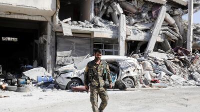 A fighter of the Syrian Democratic Forces guards a road at the frontline in Raqqa,a city in ruins on October 5, 2017. Erik De Castro / Reuters