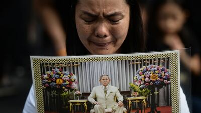 A woman cries whilst paying her respects to the late Thai King Bhumibol Adulyadej outside of the Grand Palace in Bangkok on October 15, 2016. Lillian Suwanrumpha / AFP