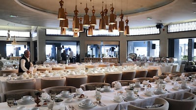 A waiter makes final table arrangements before Iftar is served. Victor Besa / The National