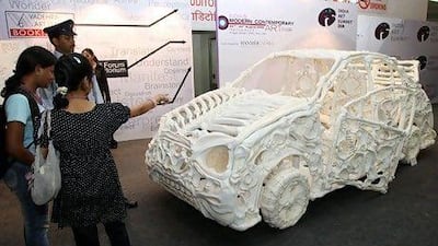The subcontinent's art market is estimated to be worth as much as 20 billion rupees. Above, visitors look at a car-like sculpture made out of material moulded in the shape of bones. Raveendran / AFP