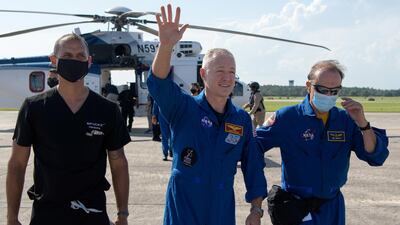 NASA astronaut Douglas Hurley waves to onlookers as he boards a plane at Naval Air Station Pensacola to return him and NASA astronaut Robert Behnken home to Houston a few hours after the duo landed in their SpaceX Crew Dragon Endeavour spacecraft. REUTERS