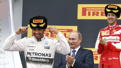 Mercedes F1 driver Lewis Hamilton celebrates victory on the podium on Sunday after the Russian Grand Prix, watched by Russian President Vladimir Putin and Ferrari driver Sebastian Vettel. Grigory Dukor / Reuters / October 11, 2015