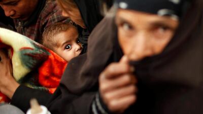 Refugees who had fled the ongoing fighting between Iraqi forces and ISIL in Mosul wait to be bussed to safety. Suhaib Salem / Reuters