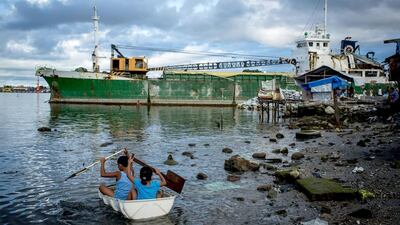 Children paddle a makeshift boat towards a large ship grounded by Typhoon Haiyan on April 18, 2014 in Tacloban, Leyte, Philippines. Chris McGrath / Getty Images