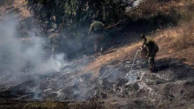 Israeli soldiers and a firefighter examine the remains of an incendiary device launched from the Gaza Strip. AP Photo