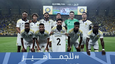 Al Nassr players pose for a team photo with the shirt of Sultan Al-Ghannam before the match. Reuters