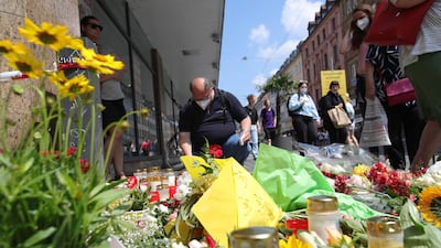 People place flowers and candles at a memorial in tribute to the victims of a deadly attack in the city of Wuerzburg, southern Germany. AFP / ARMANDO BABANI