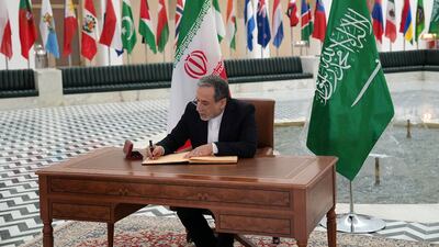 Iranian Foreign Minister Abbas Araghchi signing a book during an official visit in Riyadh. AFP