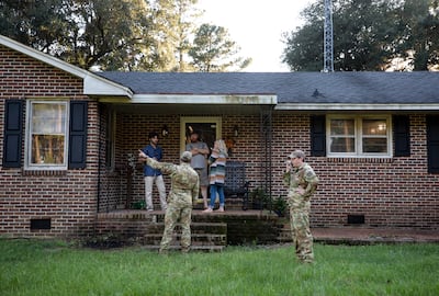 Airmen from Joint Base Charleston speak to a family living next to the site of crashed F-35 in Williamsburg County, South Carolina. The Post And Courier / AP