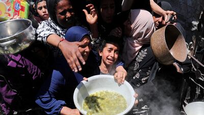 A distraught Palestinian child receives food cooked by a charity kitchen, in Beit Lahia, northern Gaza Strip, on May 8. Reuters