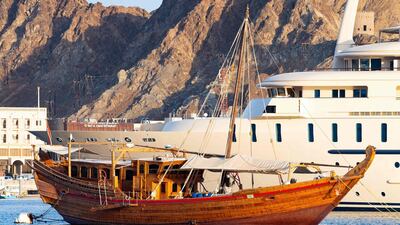 A traditional boat is moored next to a modern ship in the port of Mutrah in the Omani capital Muscat. AFP