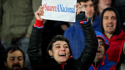 A fan of Nacional holding a poster encouraging the return of former player Luis Suarez. EPA