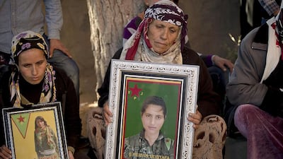 Fatma Isa Dihap holds a photograph of her 19-year-old daughter Perwin at her funeral on November 7, 2014. Perwin was fatally wounded while fighting ISIL militants in Kobani, her family’s home town. Vadim Ghirda / AP Photo