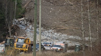Emergency vehicles and tractors at the base of a mudslide on Highway 7, west of Agassiz, British Columbia.