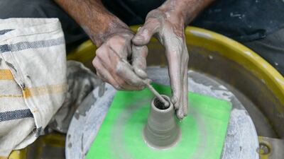 Haikan moulds the clay.