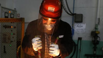 A worker processes a briquette of platinum shavings to cast ingots of 99.98 per cent pure platinum. Ilya Naymushin / Reuters