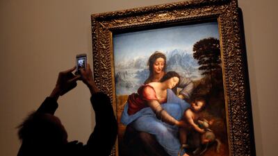 A journalist takes a snapshot of the "The Virgin and Child with Saint Anne" by Leonardo Da Vinci, at the Louvre museum, in Paris. AP