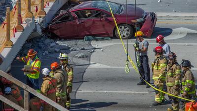Emergency personnel work on a collapsed pedestrian bridge in front of Florida International University. Giorgio Viera / EPA