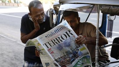 People read a newspaper the day after blasts killed hundreds in Colombo. EPA
