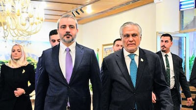 Foreground, from left, Asaad Al Shibani and Ishaq Dar, foreign ministers of Syria and Pakistan, respectively, walk side by side in Islamabad. AFP