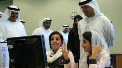 Mubarak bin Mohammed School students Ghalyah Al Hammadi, left, and Fatima Al Mazroui try the new online atlas as Dr Mugheer Khamis Al Khaili, right, looks on.