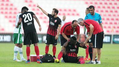 Al Ahli’s Asamoah Gyan is looked after by trainers after being tripped in the Arabian Gulf League match against Emirates on Saturday. Christopher Pike / The National