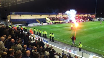 A view from the stands at Deva Stadium in Chester. Wrexham fans can be seen at the far end during the English Football Conference match againt old rivals Chester and Wrexham on Tuesday. A moment of silence to commemorate the 80th anniversary of a mining disaster that killed 266 was broken by a Chester fan shouting abuse, bringing outrage from the Wrexham fans present. A flare is thrown on the pitch as police line the touchline before the start of the match. Andy Mitten for The National